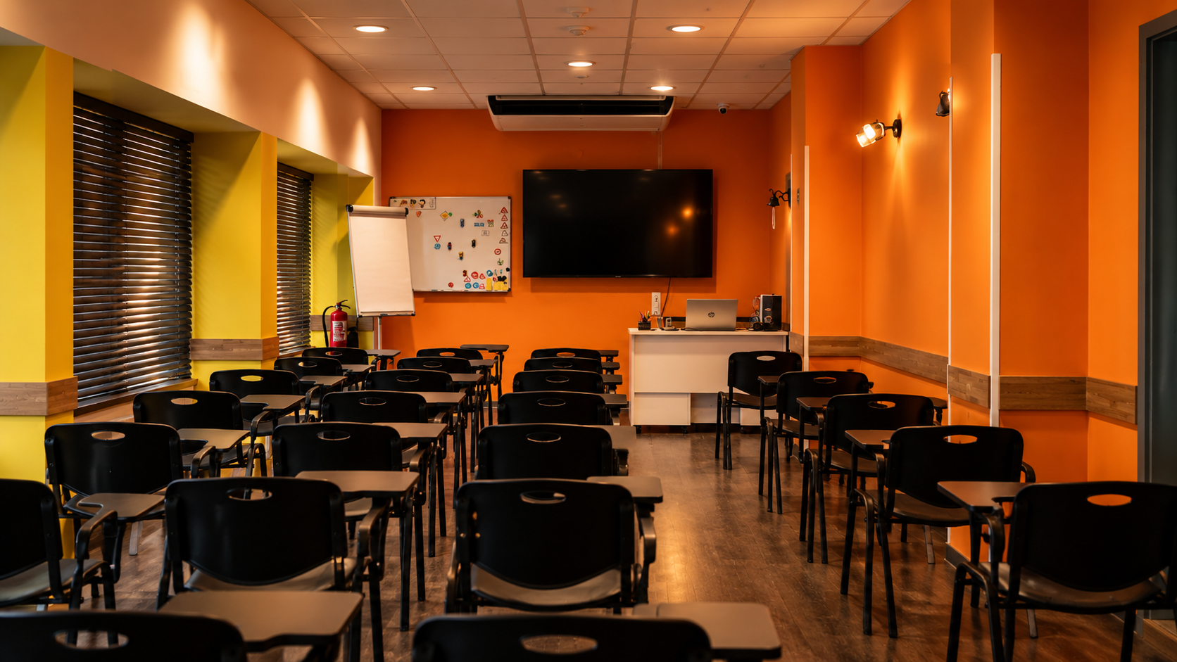 Moderner Unterrichtsraum mit Tischreihen und Leinwand